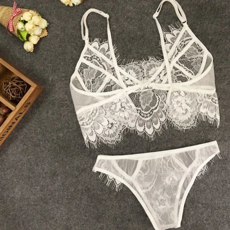 White lace bralette and thong set, crisscross straps and scalloped floral lace edging.