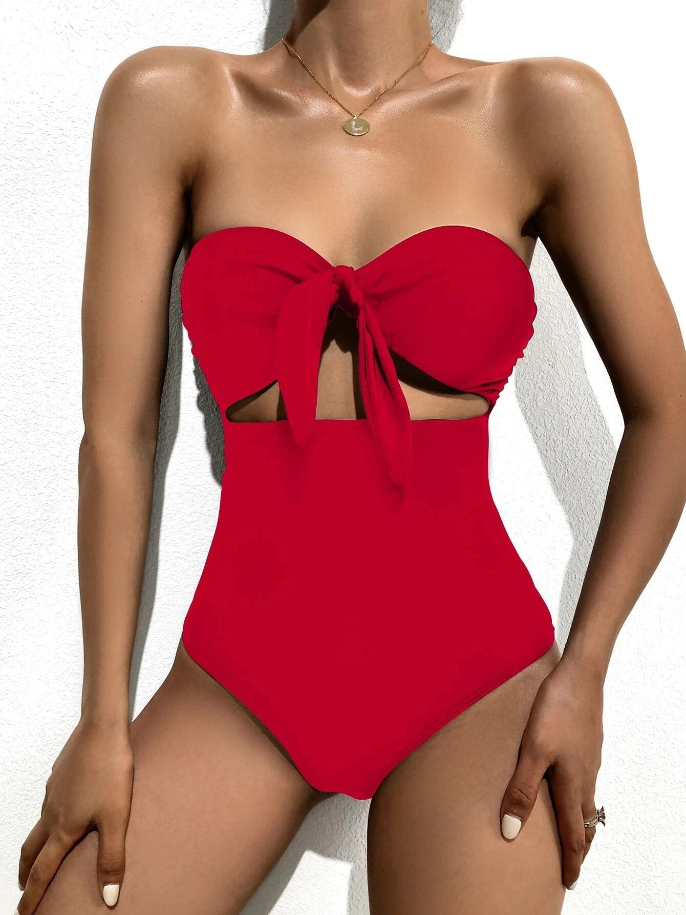 Red bandeau one-piece swimsuit with front bow and midriff cutout