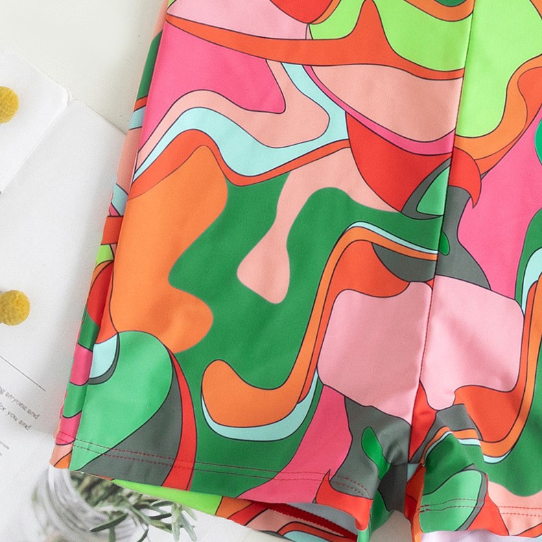 One-piece swimsuit shorts front with colorful abstract retro print and stitched seams