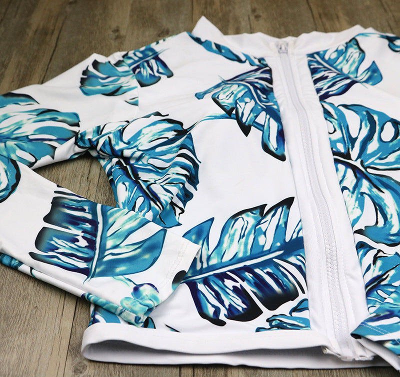 One-piece swimsuit top section with teal leaf print and white front zipper closure