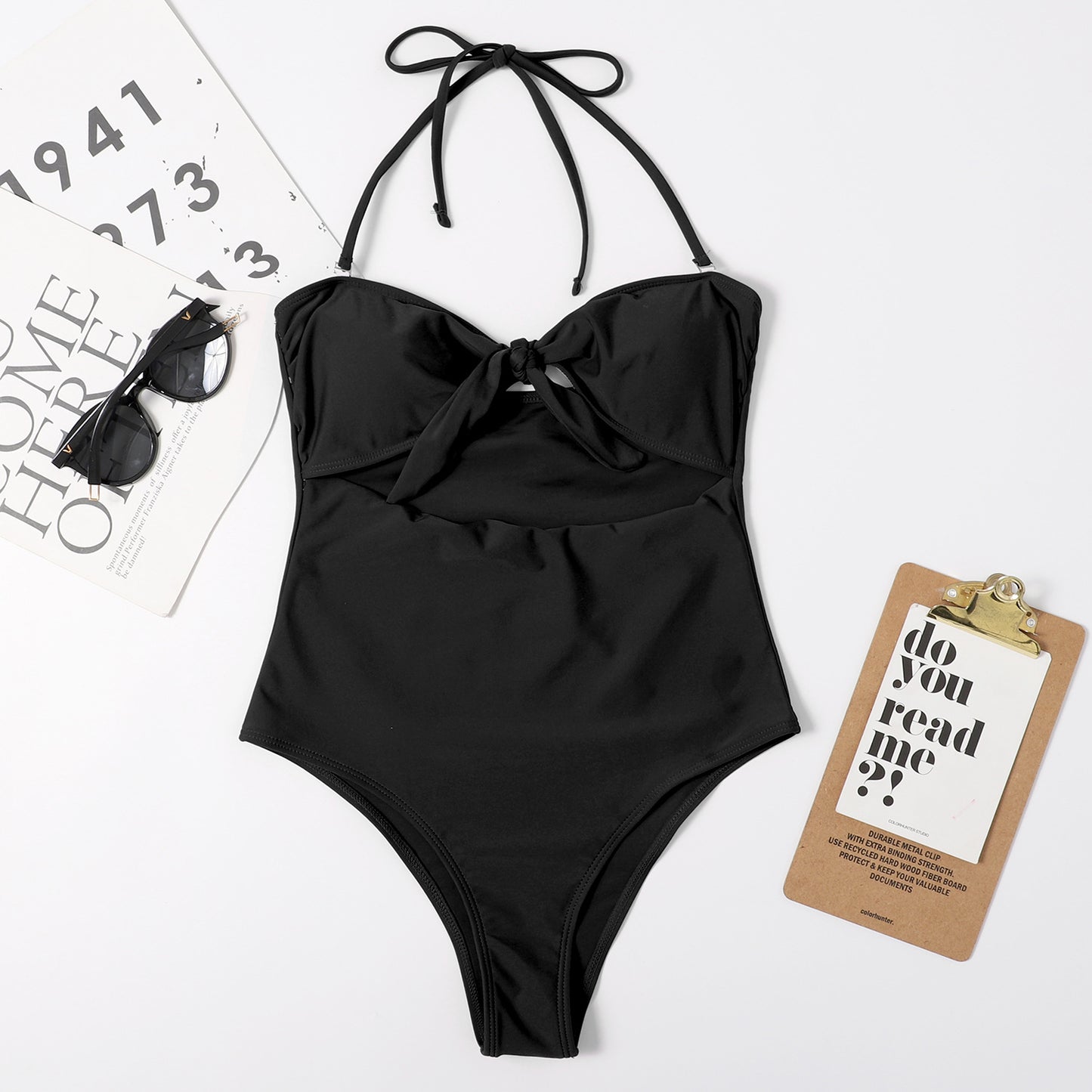 Black bandeau one-piece swimsuit with bow at bust and tie halter straps