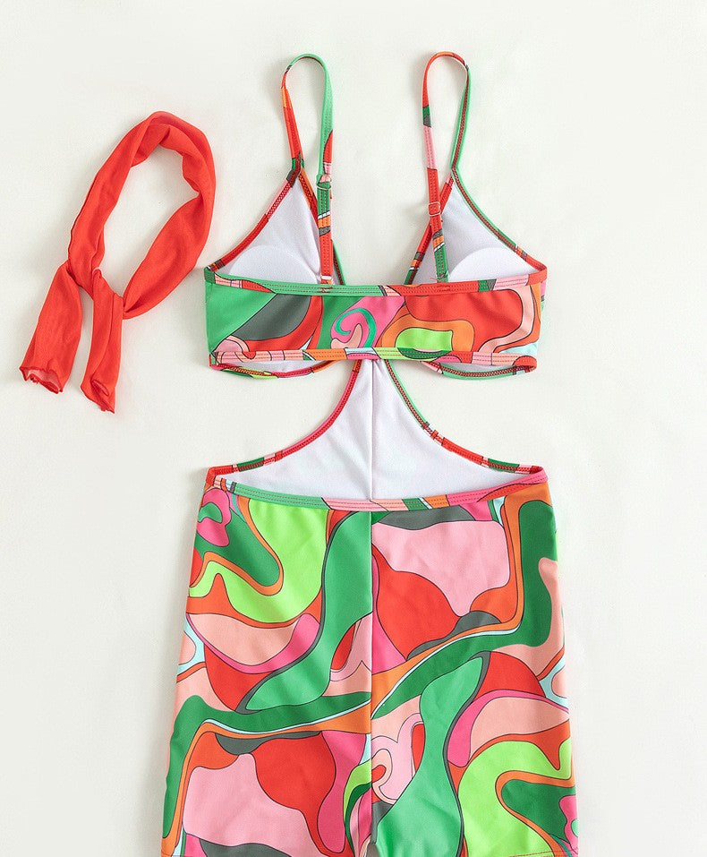One-piece swimsuit flat lay with colorful abstract retro print, halter top and matching shorts