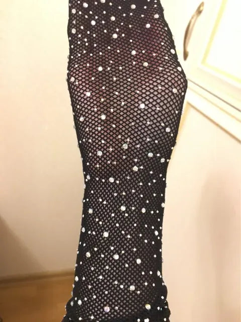 Black fishnet mesh tights with rhinestone dots, full leg length close-up