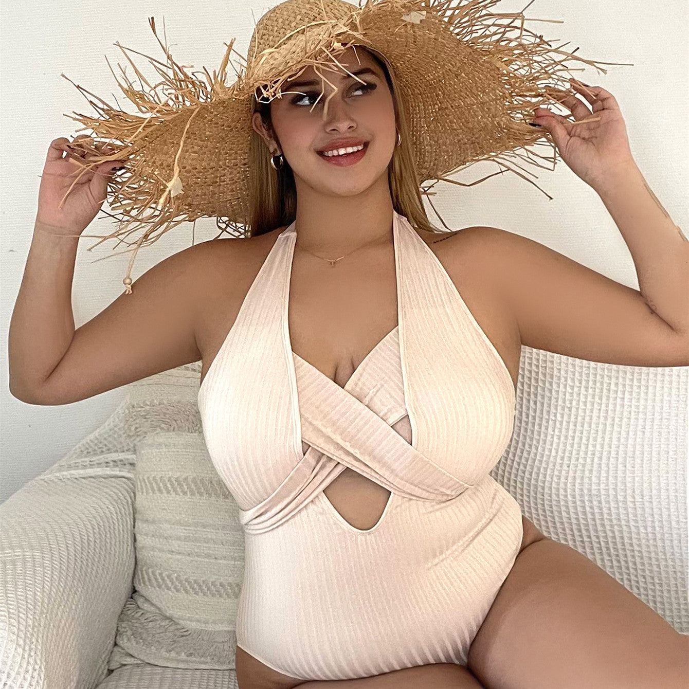 Beige ribbed one-piece swimsuit with halter neck and crisscross cutout at bust