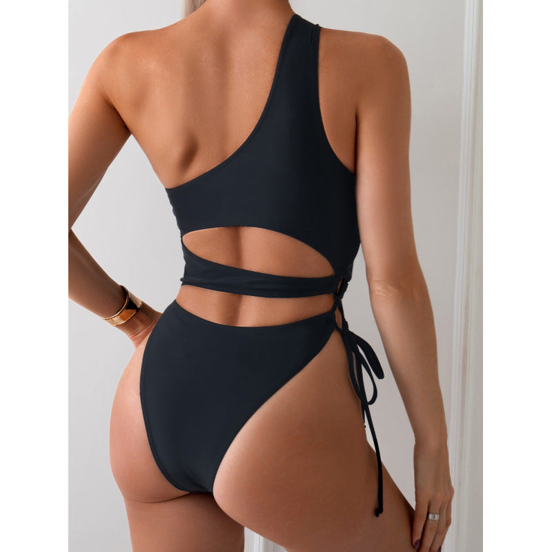 Hollowed-out one-shoulder one-piece swimsuit in black, back view with tie side.