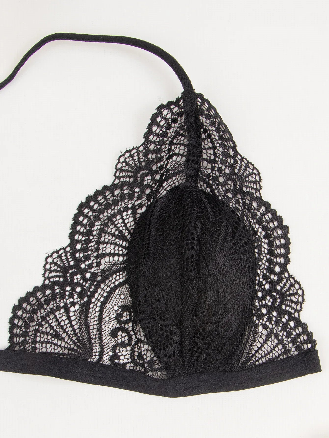 Black lace bra close-up: textured lace cup with scalloped edging and underband